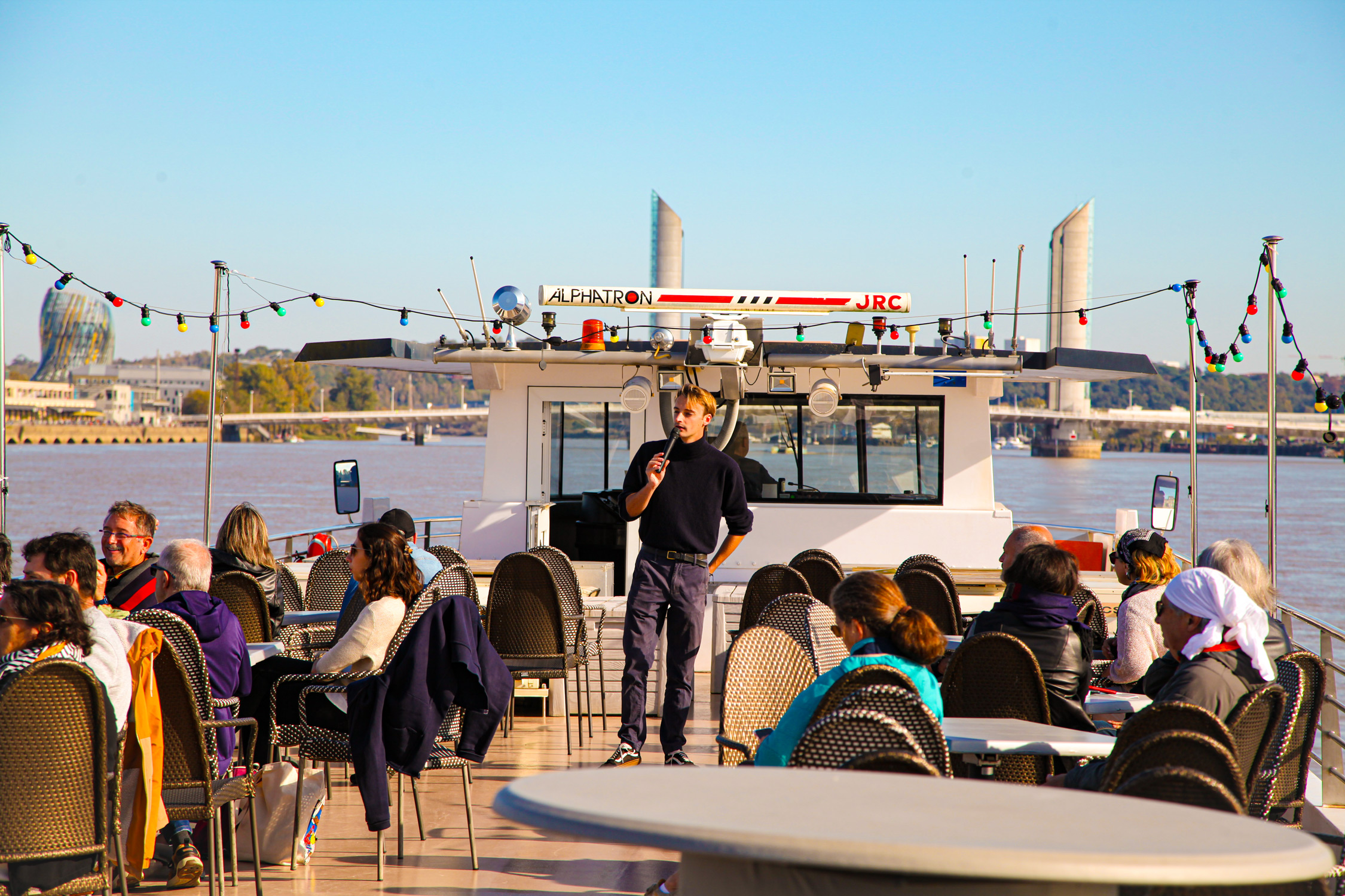 Robin, l'un de nos guides, en pleine croisière commentée sur le pont supérieur du Burdigala 2, offrant une vue panoramique à 360° pour les passagers sur tout Bordeaux